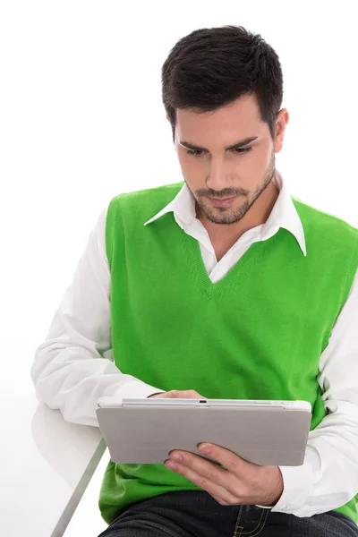 Hombre guapo joven aislado está mirando la tableta pc en bac blanco — Foto de Stock