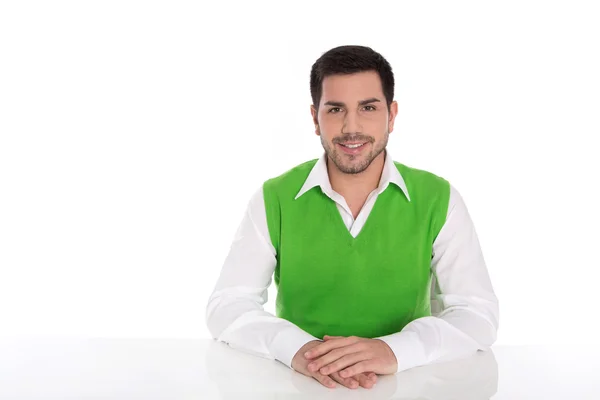 Isolado jovem sorridente empresário sentado na mesa em branco . — Fotografia de Stock