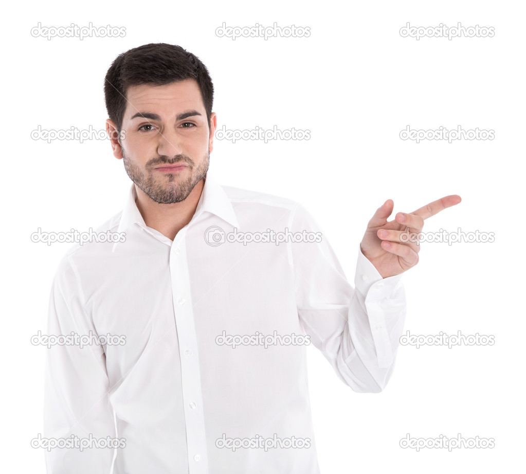 Isolated handsome young man is pointing with index finger on whi