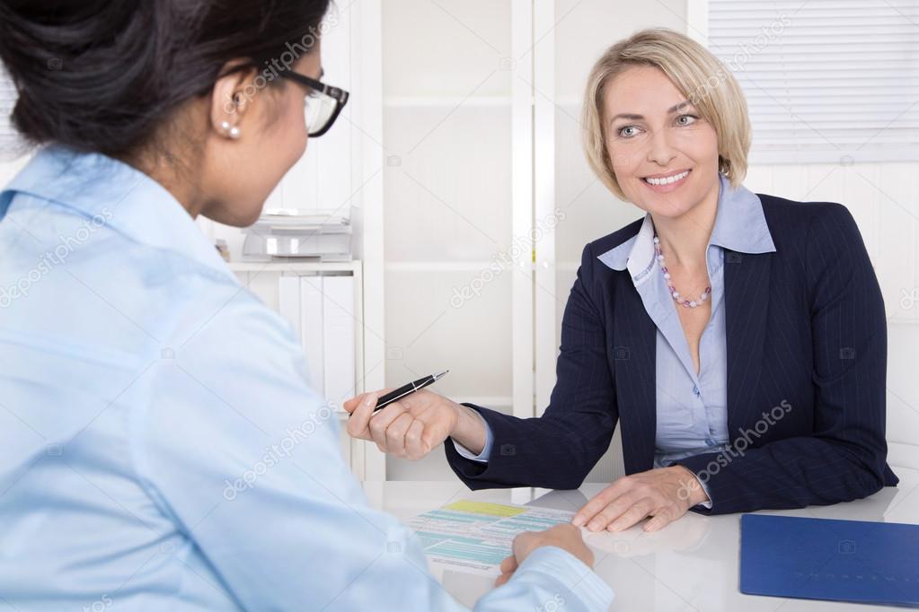 Senior business woman in interview with a trainee - application for a job.