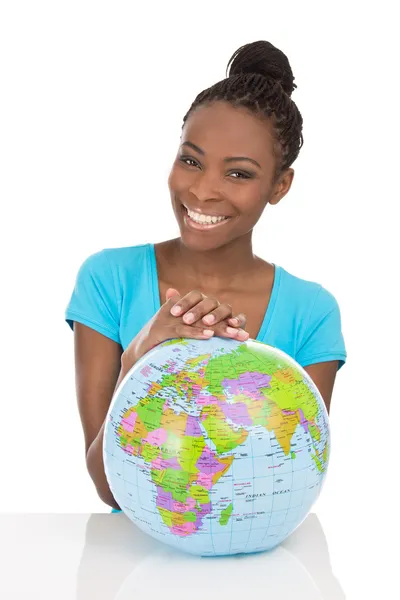 Geïsoleerde Afrikaanse Amerikaanse lachende vrouw zitten met globe in fr — Stockfoto