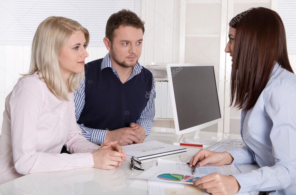 Young attractive couple at consultation with female consultant.