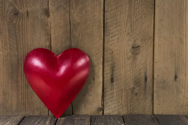 Κόκκινη καρδιά μέταλλο σε ξύλινα φόντο Εικόνα Αρχείου