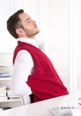 genç yakışıklı katip ofisinde sırt ağrısı ile.