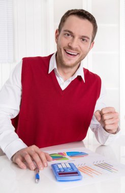 Successful young accountant working with diagrams at desk. clipart