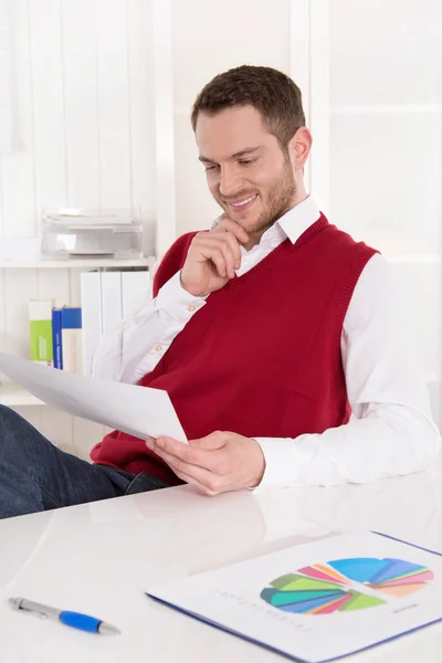 Zufriedener Controller mit Diagrammen am Schreibtisch im Büro. — Stockfoto