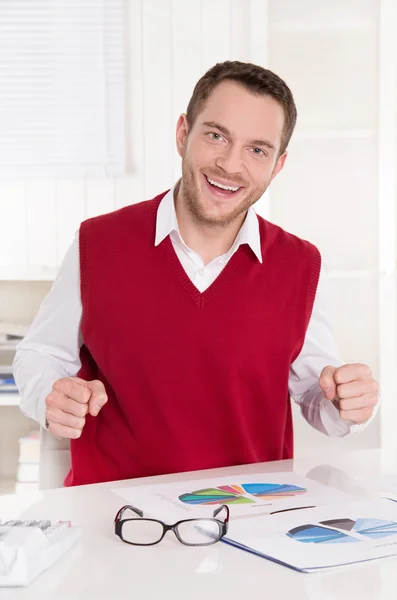 Zufriedener Buchhalter mit Fäusten am Schreibtisch im Büro. — Stockfoto