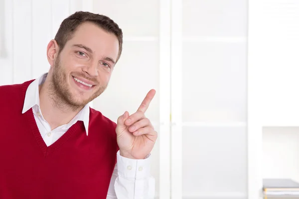 Atractivo hombre de negocios sonriente con el dedo índice en la oficina . —  Fotos de Stock