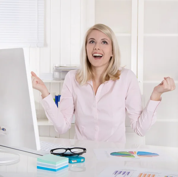 Gelukkig succesvol jonge bedrijf vrouw met armen omhoog aan balie. — Stockfoto