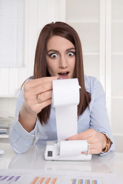 Junge schockierte Buchhalterin mit offenem Mund beim Blick aufs Rechnen — Stockfoto