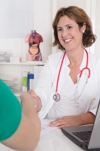 Ritratto di medico bruna seduto in uniforme stretta di mano w — Foto Stock