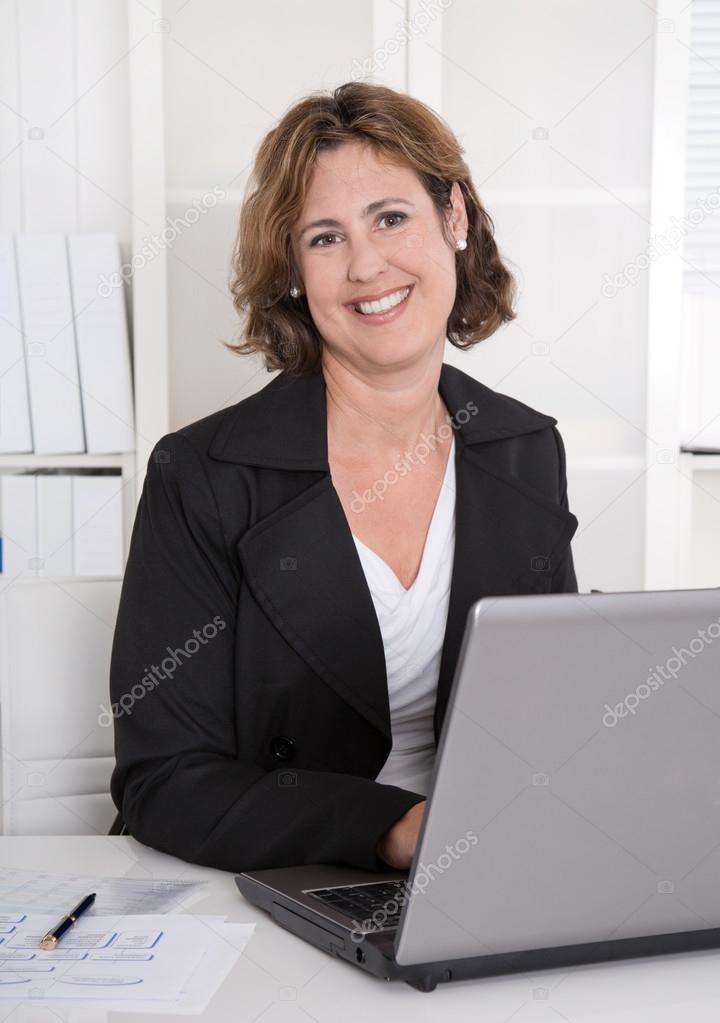 Portrait of pretty happy smiling businesswoman working with lapt