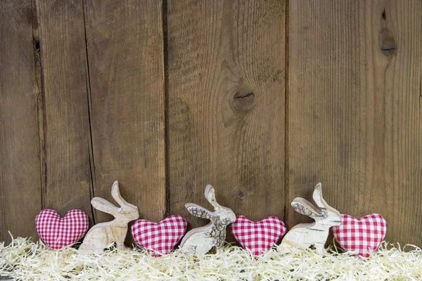 Rode gecontroleerd harten op houten achtergrond voor Pasen. — Stockfoto