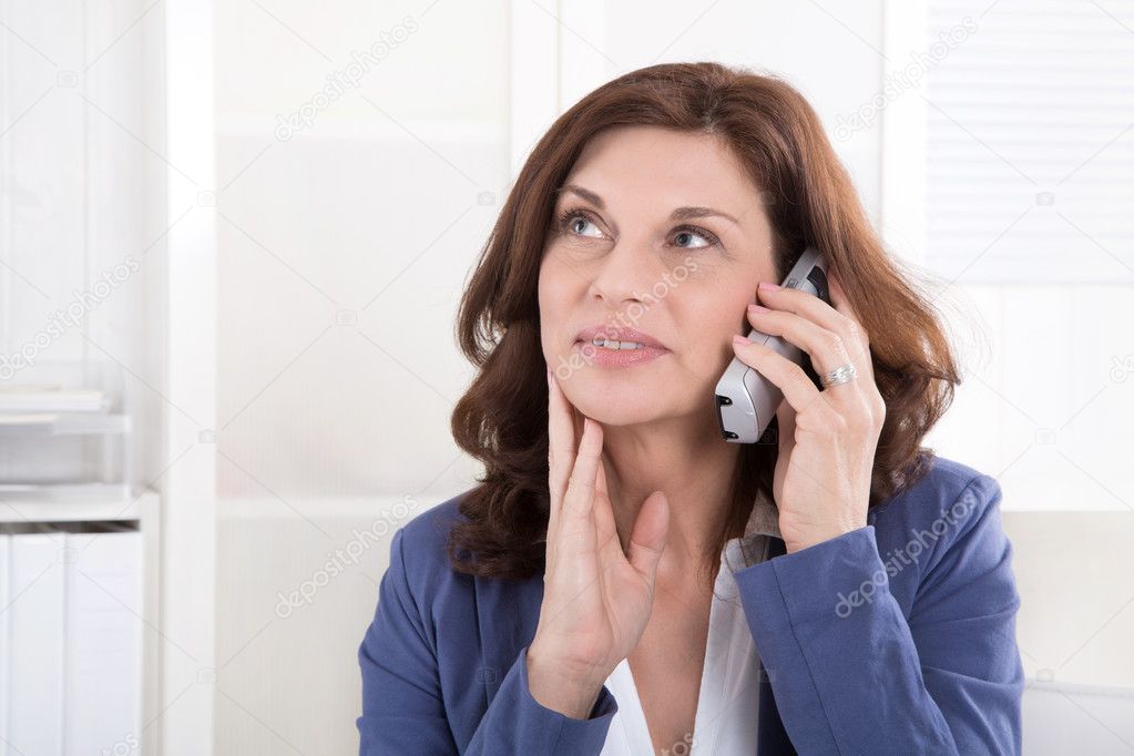Older attractive business woman making a phone call.