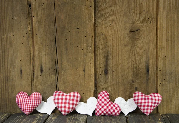 Wooden board decorated with checked hearts for a greeting card. Royalty Free Stock Photos