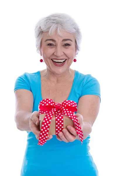 Feliz mujer mayor aislada sosteniendo un regalo . — Foto de Stock