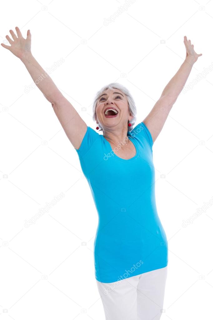 Cheering happy older woman isolated in a blue shirt.