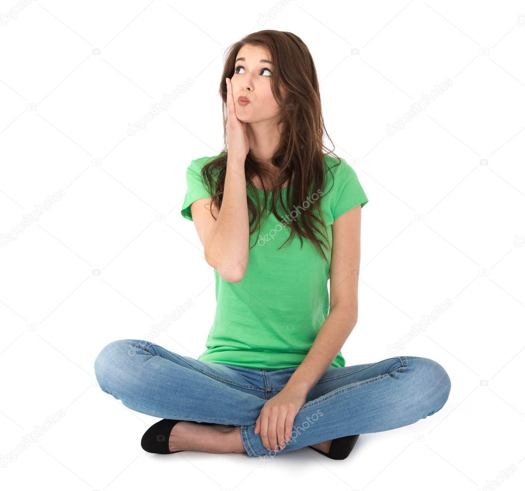 Isolated young woman sitting in crossed legs on the floor.