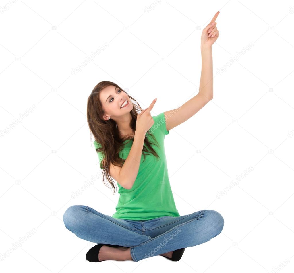 Isolated young woman sitting with crossed legs is presenting.