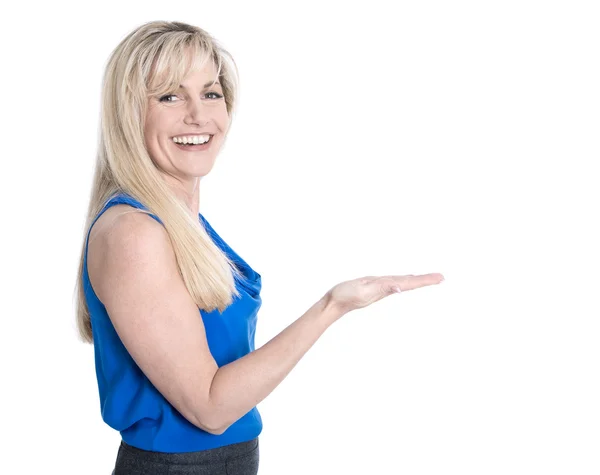 Isolierte blonde reife Frau präsentiert mit der Hand über Weiß. — Stockfoto