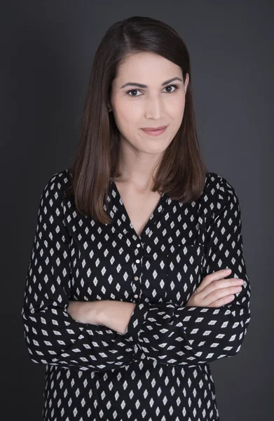 Retrato de uma mulher isolada de cabelos escuros em preto . — Fotografia de Stock