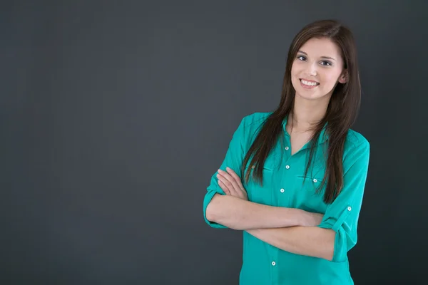 Portrait of a young happy woman isolated on a blackboard. — Stock Photo, Image