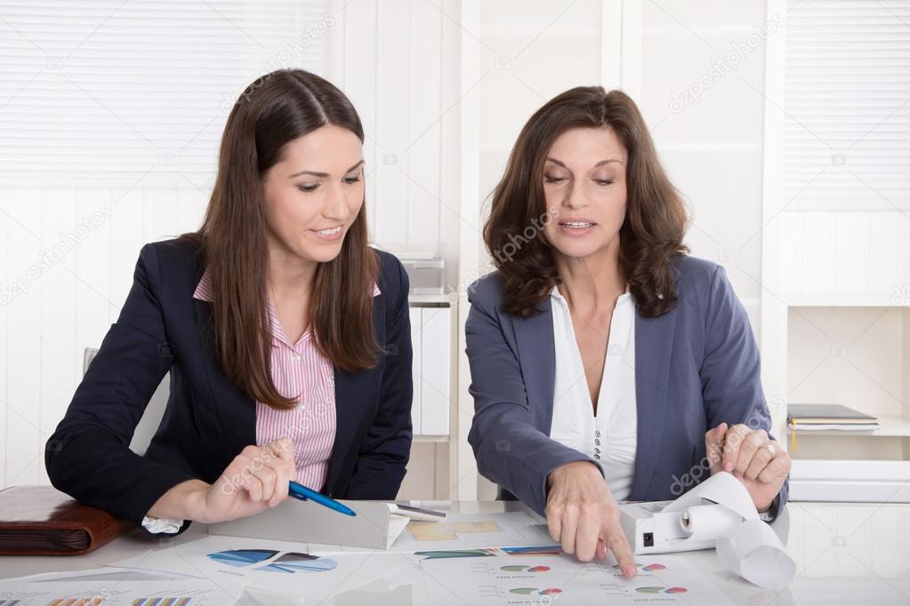 Two business woman analyzing balance sheet.
