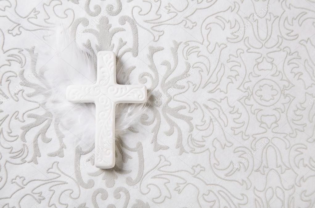 Mourning: white ceramic cross on grey ornament background.
