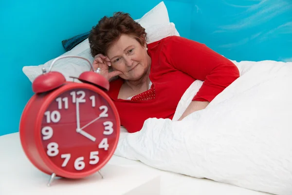 Mujer mayor en cama enferma y sufrida de insomnio o insomnio — Foto de Stock