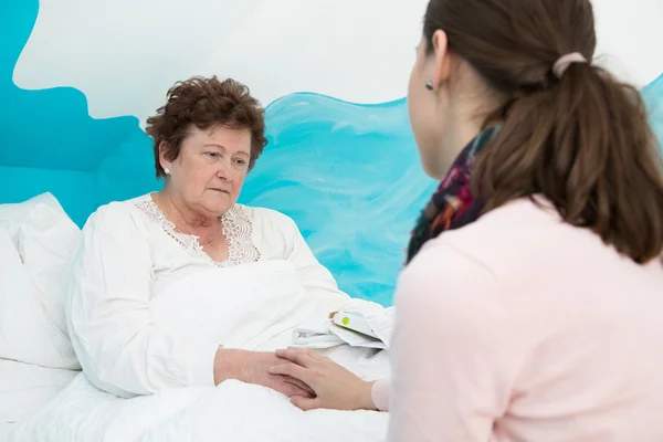 Illness: Older woman lying sick in the bed. — Stock Photo, Image