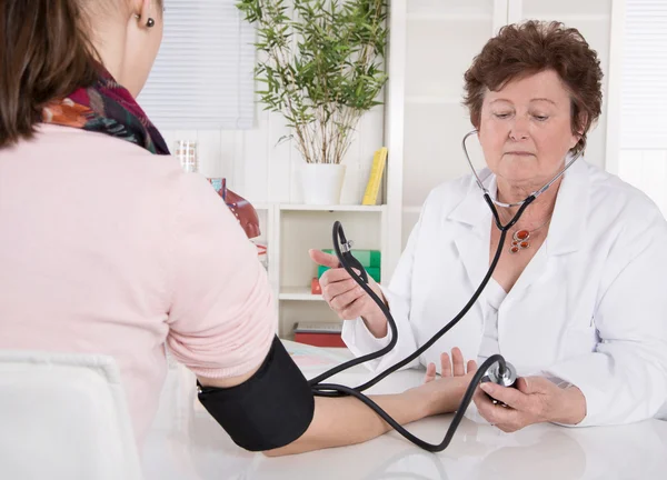 Médico sénior que mide la presión arterial con paciente . — Foto de Stock