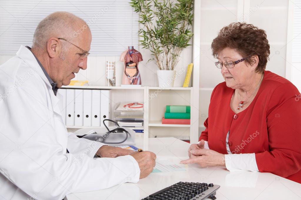 Portrait of an older doctor talking with his female patient.