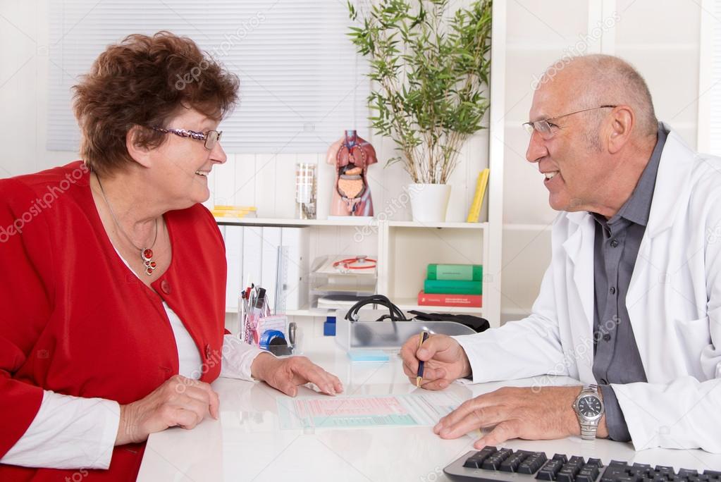 Portrait of an older doctor talking with a female patient.