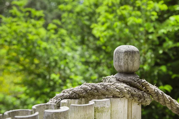 Corda di nodo sulla recinzione in giardino. Sfondo verde . — Foto Stock