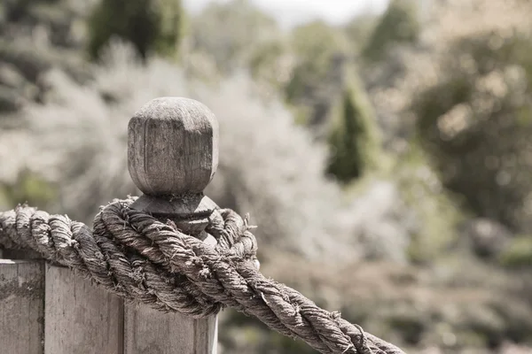 Knot rope on the fence in the garden. Country style background. — Stock Photo, Image