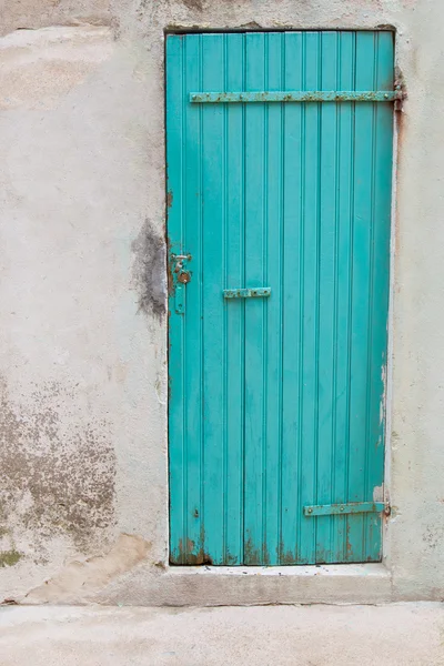 Una vieja puerta de madera turquesa o verde en una casa vieja . — Foto de Stock