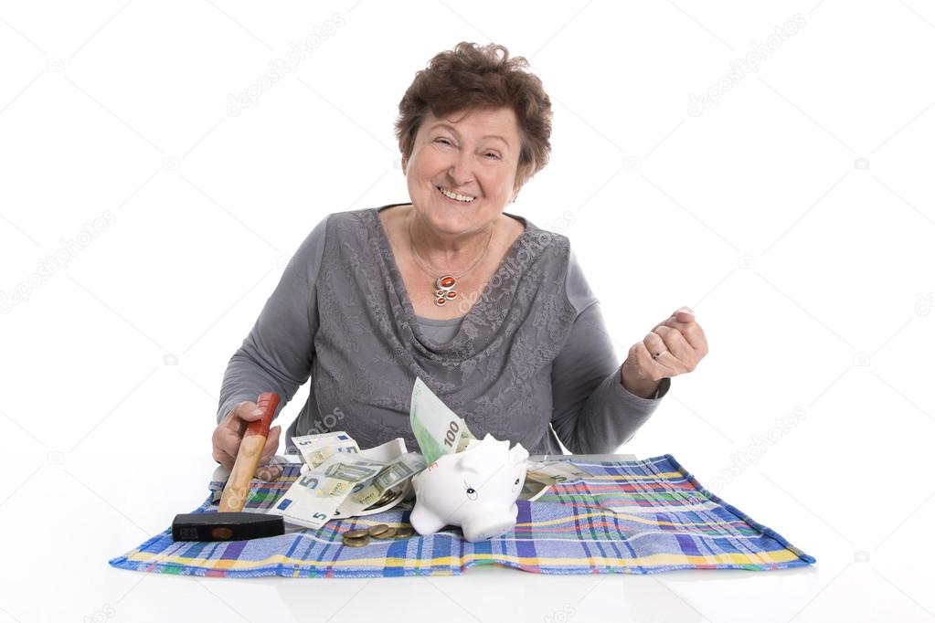 Happy older woman - rich person after smashing piggy bank.
