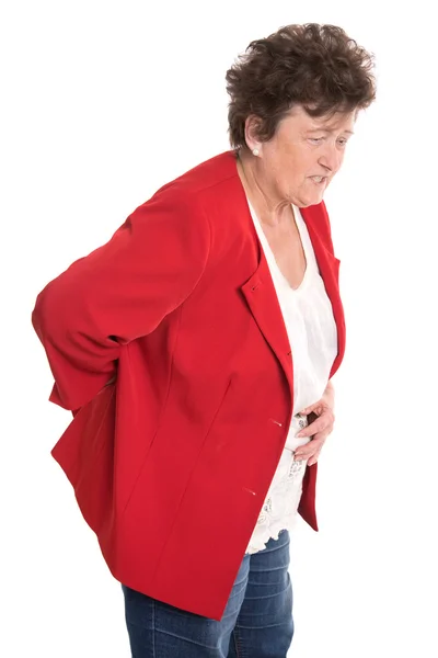 Donna anziana isolata in rosso ha mal di schiena o reumatismi . — Foto Stock