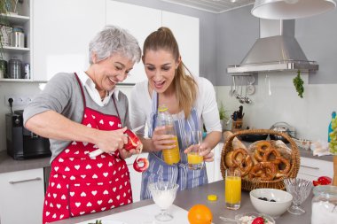 Anne ve kızı birlikte kahvaltı hazırlarken.