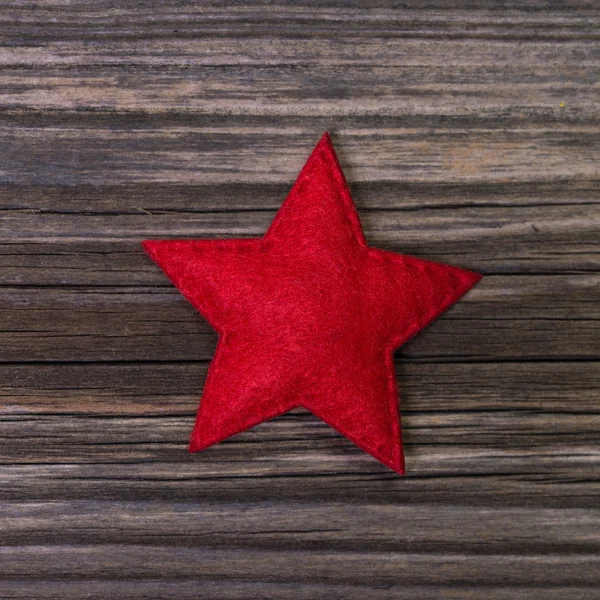 Red christmas star of felt on wooden background for decoration. — Stock Photo, Image
