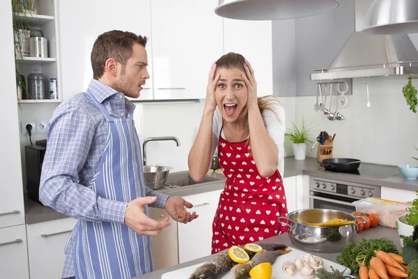 Pareja joven gritando en casa en la cocina . Imagen De Stock