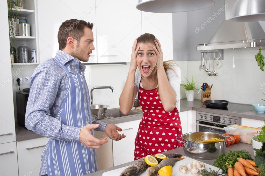 Young couple screaming at home in the kitchen.