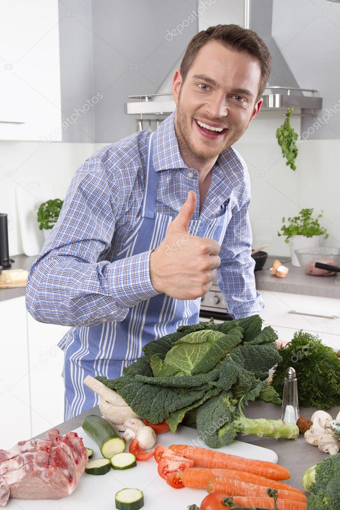 Man in the kitchen with thumb up preparing dinner.