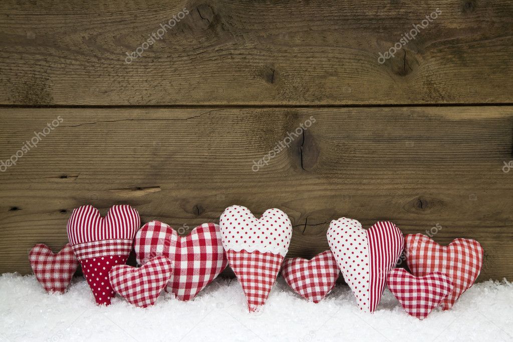 Handmade red white checked hearts on a wooden christmas backgrou