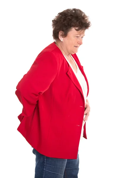 Isolado sênior do sexo feminino em vermelho tem dor nas costas ou reumatismo . — Fotografia de Stock