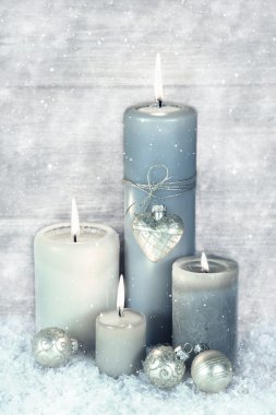 dört mavi, gri ve beyaz kar ile Noel mumlar yanan