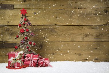 Kırmızı hediyeler ve ahşap karlı backgr kar ile Noel ağacı