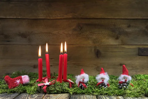Quattro candele rosse ardenti di Natale su sfondo di legno con gre — Foto Stock