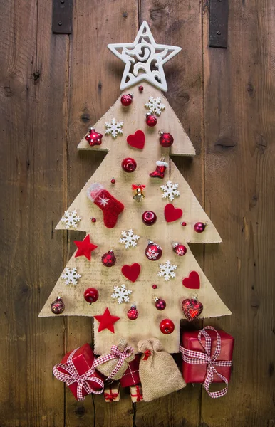 Dekoration: handgeschnitzter Weihnachtsbaum mit roten Miniaturen. — Stockfoto