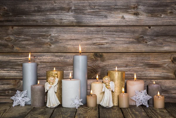 Decoración navideña con velas y ángeles sobre fondo de madera — Foto de Stock